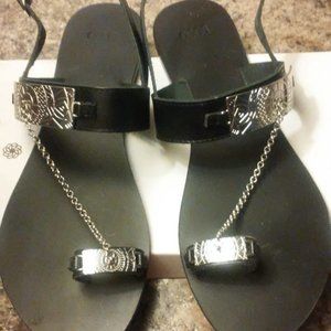 Black ladies sandals with metal chain and design.